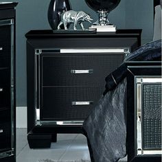 a bedroom with black furniture and silver accents