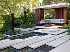 an outdoor living area with couches, tables and water features in the foreground