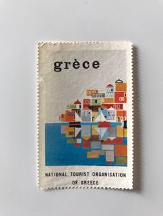 a stamp with the words greece on it and an image of a small town in the background