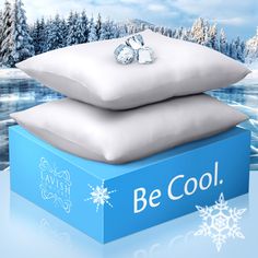 two pillows are stacked on top of each other in front of a winter scene with snowflakes