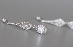 "Elegant 'modern-vintage' Bridal earrings have been designed in a delicate open-work style studded with cubic zirconium crystals with a crystal teardrop, to add a gorgeous delicate sparkle to your wedding day. Set in tarnish resistant 18K Rhodium (White Gold Plate) with high quality cubic zirconium crystals for heirloom quality. Allergy free. L = 1 3/4\" (4.5 cm) Our model wears our store sample ear post. ★Shopping for your bridal party? Contact us for special pricing. Please read our shop polic Silver Diamond Earrings With Intricate Design For Wedding, Ornate Wedding Diamond Drop Earrings, Silver Cubic Zirconia Diamond Earrings With Intricate Design, Wedding Crystal Diamond Earrings (pierced), Wedding Crystal Diamond Earrings Pierced, Wedding Diamond Crystal Earrings Pierced, Pierced Diamond Crystal Earrings For Wedding, Wedding Filigree Diamond Earrings, Wedding Diamond Filigree Earrings