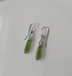 Drop shape Canadian Jade delicate earrings. Genuine nephrite stone earrings. Delicate short green stone earrings. Nice quality natural Canadian Jade from B.C. and sterling silver. Total length with closer is 3,5 cm. Each pair comes with security backings and a nice little bag ready for gift. Green Pierced Drop Earrings, Green Minimalist Pierced Earrings, Minimalist Green Pierced Earrings, Green Minimalist Dangle Earrings, Green Drop Earrings, Pierced, Minimalist Green Teardrop Earrings, Green Gemstone Teardrop Earrings, Green Teardrop Gemstone Earrings, Teardrop Jade Earrings