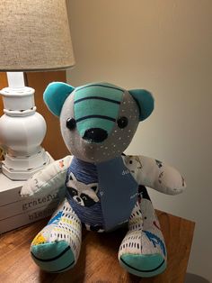 a stuffed animal sitting on top of a wooden table next to a lamp and book