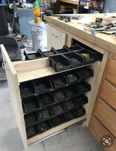 an open cabinet filled with lots of black containers