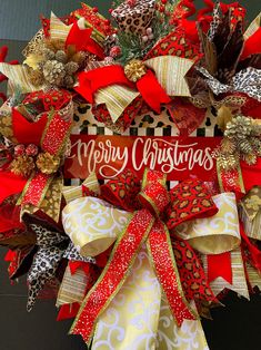 a christmas wreath with red and gold ribbons