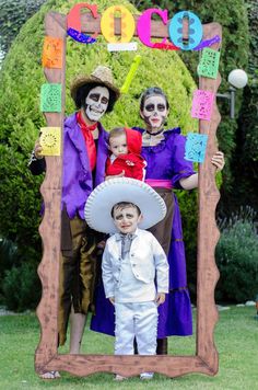 a group of people in costumes posing for a photo with a child wearing a sombrero