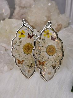 Exquisite pressed wildflower earrings in White and Yellow hues. Each bloom is meticulously positioned with a toothpick and a steady hand. Small crystals are sprinkled throughout for subtle shimmer.  They are extra large in size, featuring sterling silver French hooks, and are hypoallergenic. Available in a spectrum of colors. For custom-made pairs, please send a message. Dangle Flower Earrings With Natural Inclusions As Gift, Dangle Earrings With Natural Inclusions For Gift, Silver Jewelry With Pressed Flowers, Nature-inspired Nickel Free White Earrings, Clear Pressed Flower Earrings As Gift, Dainty White Earrings With Pressed Flowers, Botanical White Birth Flower Earrings, Botanical Style Silver Earrings For Gift, Silver Pressed Flowers Earrings For Gift