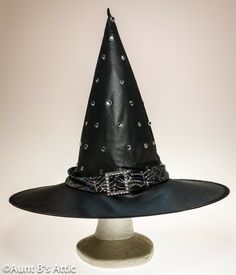 Dressy jeweled witch hat, is in a black poly, that has almost a satin shine to it. Trimmed with a silver spider web design band, and accented with a rhinestone buckle. Includes an extra pack of jewels. 5" wired brim, 14 1/2" crown. Very pretty! Halloween Costume Hat Accessories, Novelty Halloween Costume Cap, Halloween Costume Hat, Novelty Brimmed Halloween Costume Hats And Headpieces, Novelty Brimmed Halloween Costume Hat, Halloween Costume Cap, Themed Halloween Costume Cap Accessories, Themed Halloween Costume Cap, Adjustable Curved Brim Costume Accessories For Halloween