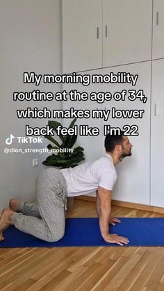 a man is sitting on the floor in front of a wall with his feet up