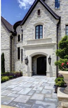 a large stone house with landscaping around it