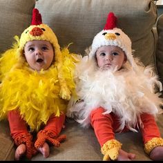 two babies dressed in costumes sitting on a couch