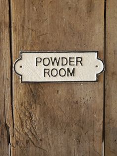 a wooden door with a sign that says powder room