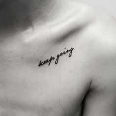 a woman's chest with the words keep going written on it, in cursive font