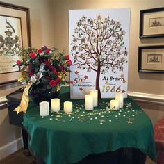 a table with candles and flowers on it in front of a sign that says al brown