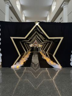 the entrance to an event with black and gold decorations