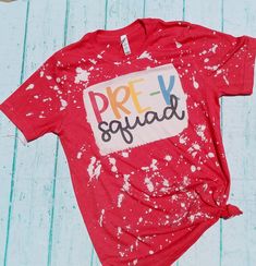 a red t - shirt with the words prev squad painted on it