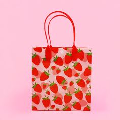 a strawberry print shopping bag on a pink background