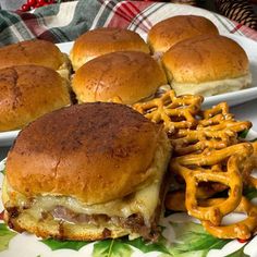 a plate topped with sliders and pretzels on top of a floral plate