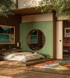 a bedroom with green walls and wooden flooring next to a bed in front of a mirror