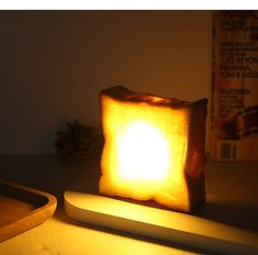 a lit candle sitting on top of a table next to a cutting board and knife