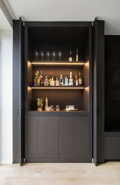 an empty bar with bottles and glasses on the shelves