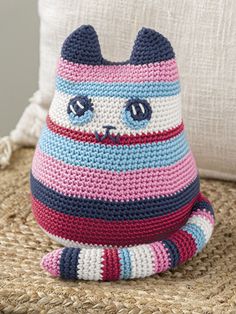 a crocheted cat sitting on top of a couch