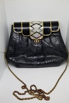 Vintage faux snake skin rhinestone hand bag Black faux snake skin with a metal top also covered in black faux snake skin with black and grey rhinestones. Gold tone hardware and detailing Chain can be used as a shoulder bag or tucked inside Original label has come off so, we do not know the maker. Made in Hong Kong Extra rhinestones are included in case any ever lost. One interior zipper Faux leather lining In great vintage condition. A little bit of light wear and tarnish to gold tone strap 6 in Luxury Snake Print Evening Bag, Luxury Evening Bag With Snake Print, Luxury Snake Print Shoulder Bag For Evening, Black Evening Bag With Magnetic Closure For Party, Elegant Snake Print Shoulder Bag, Elegant Snake Print Evening Bag, Elegant Formal Snake Print Bag, Elegant Rectangular Shoulder Bag With Snake Print, Elegant Rectangular Snake Print Shoulder Bag