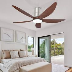 a bed room with a neatly made bed and a ceiling fan in the middle of it