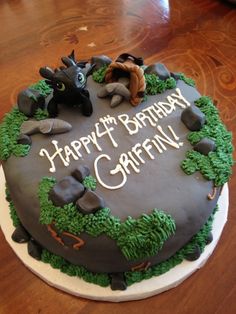 a birthday cake decorated with green and brown icing on top of a wooden table