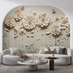 a living room with white furniture and large flowers on the wall behind it's couches