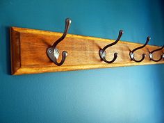 three hooks are attached to a wooden coat rack