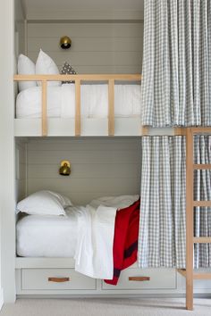 a bunk bed with white sheets and pillows