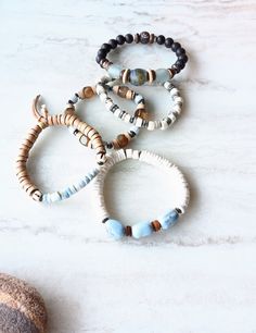 Beautiful mix of of light and dark and of neutrals plus a few pops of beachy color. White, beige, silver blue, gray-green, gray-blue, brown, dark browns, and touches of mustards. Bone beads, fused glass disks, recycled glass beads, Ebonywood, colorful glass Chevron beads, coconut disks, Agate, and several Jasper gemstones. Blended in with natural shell, mixed metal accents, and various spacer beads. The item/s pictured is the item you will receive. Bracelets are 7.0" to 7.5" in length.  HavSolSt Adjustable Blue Beaded Earthy Bracelet, Adjustable Earthy Blue Beaded Bracelets, Earthy Natural Stone Beaded Bracelets For Beach, Casual Beaded Bracelets With Natural Stones For Beach, Casual Beach Beaded Bracelets With Natural Stones, Earthy Hand-wrapped Bracelets For The Beach, Earthy Hand Wrapped Bracelets For Beach, Bohemian Recycled Glass Bracelets For Beach, Bohemian Adjustable Bracelets With Recycled Glass