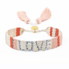 the love bracelet with tassels is made from yarn and has an inscription on it