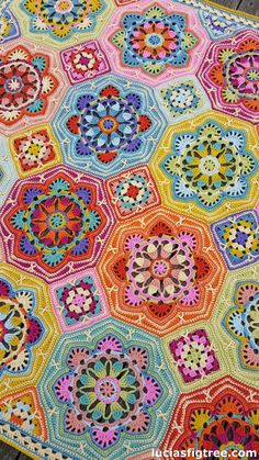 a multicolored crocheted rug is shown on the wooden floor, and it looks like hexagons