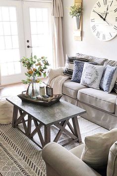 a living room with two couches and a coffee table in front of a clock on the wall