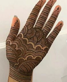 the hand is decorated with henna designs on it's fingers and palm area