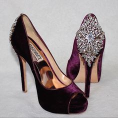 a pair of purple high heeled shoes with jewel embellishments on them