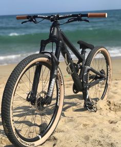 a bicycle parked on the beach near the ocean