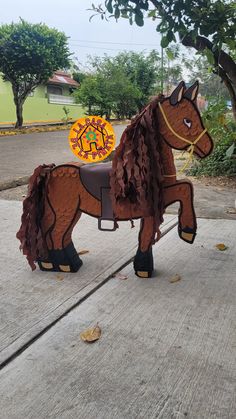 a brown horse statue sitting on top of a sidewalk