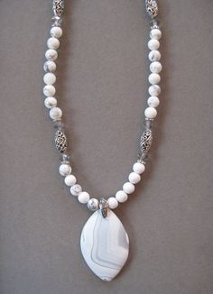 This is a beautiful White Diamond Shaped Striped Onyx Agate. It is 16 inches long and adjustable to 21 inches with a lobster clasp and chain. The pendant measures 2 inches long by 1 13/8 inches wide. The beads in the chain are white tourmaline and match the pendant stone with crystal accent beads.   It comes with a card describing the Stone Qualities. All my jewelry is unique and one of a kind. Similar quality jewelry is priced at double. I source the stone pendants from all over the world. All White Adjustable Beaded Necklace With Gemstone, White Adjustable Gemstone Beaded Necklace, Adjustable White Gemstone Beaded Necklaces, White Adjustable Gemstone Beaded Necklaces, White Agate Beaded Necklace With Gemstone, White Gemstone Beaded Pendant Necklace, White Beaded Pendant Necklace With Gemstones, White Agate Jewelry With Polished Beads, White Agate Gemstone Beads Necklaces