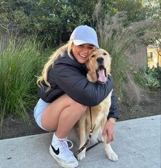 a woman sitting on the ground with her dog