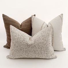 three pillows sitting next to each other on a white surface