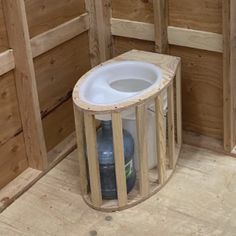 a toilet in the corner of a room with wooden walls