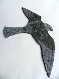 a bird made out of tiles sitting on top of a table