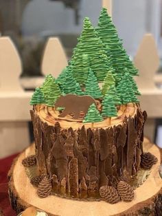 there is a cake decorated with trees and animals on the top of this tree stump