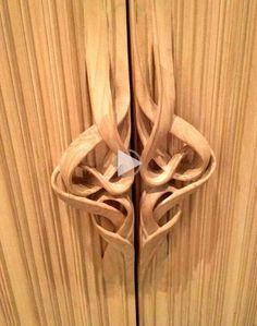 a close up of a wooden door handle with an intricate design on the front and side