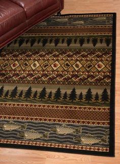 an area rug on the floor with a leather couch in front of it and a brown chair