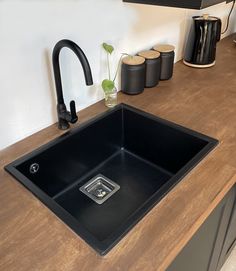 a black sink sitting on top of a wooden counter