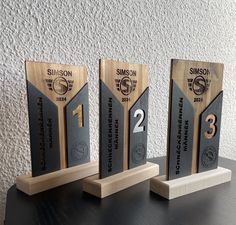 three wooden trophies sitting on top of a table